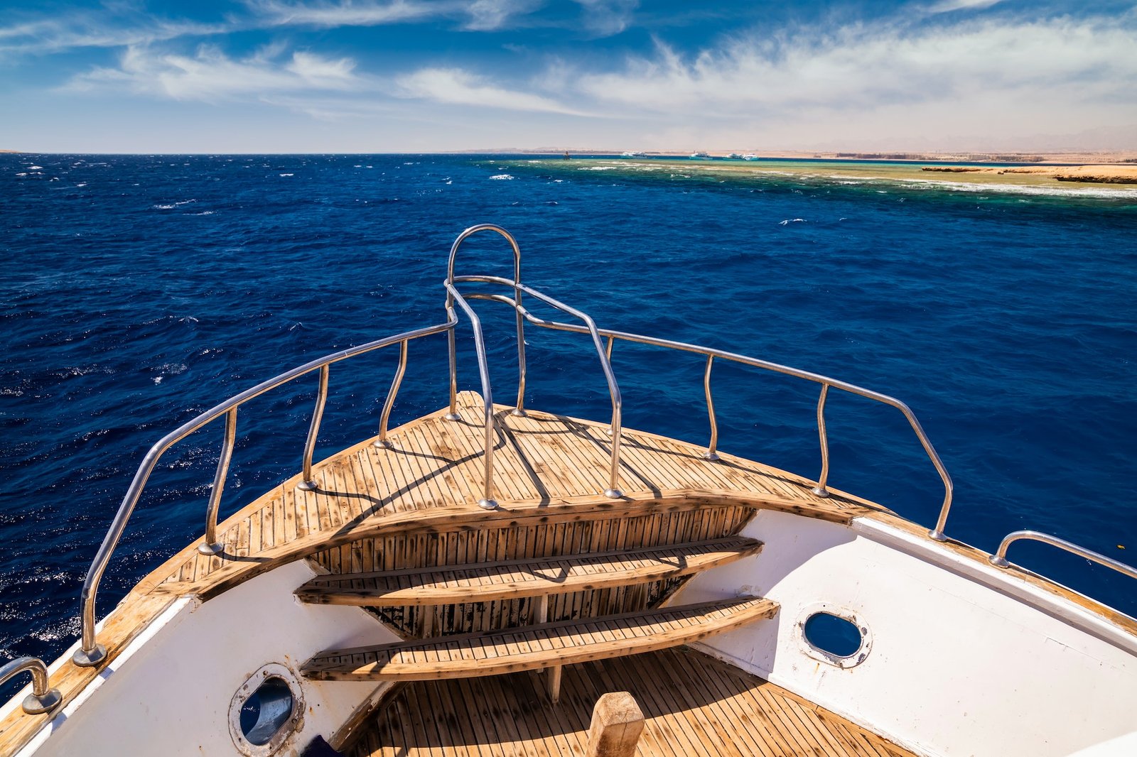 Cruise yacht bow in clear water near a coral reef. Red Sea, Egypt