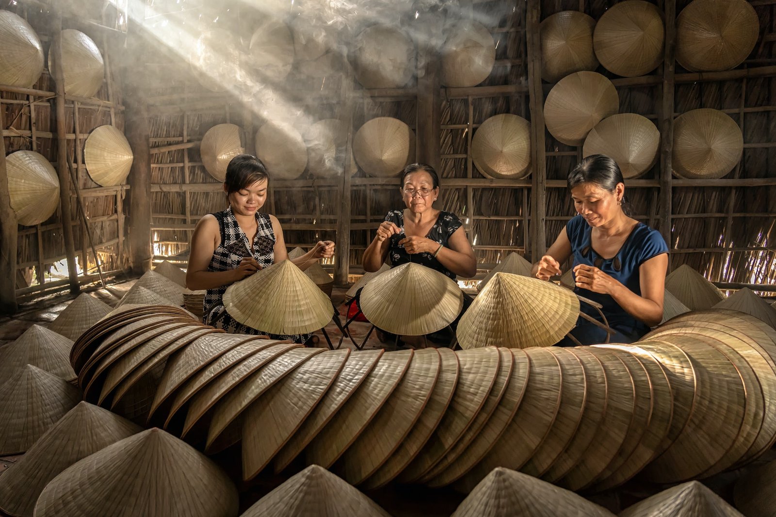 Group of Vietnamese female craftsman making the traditional vietnam hat