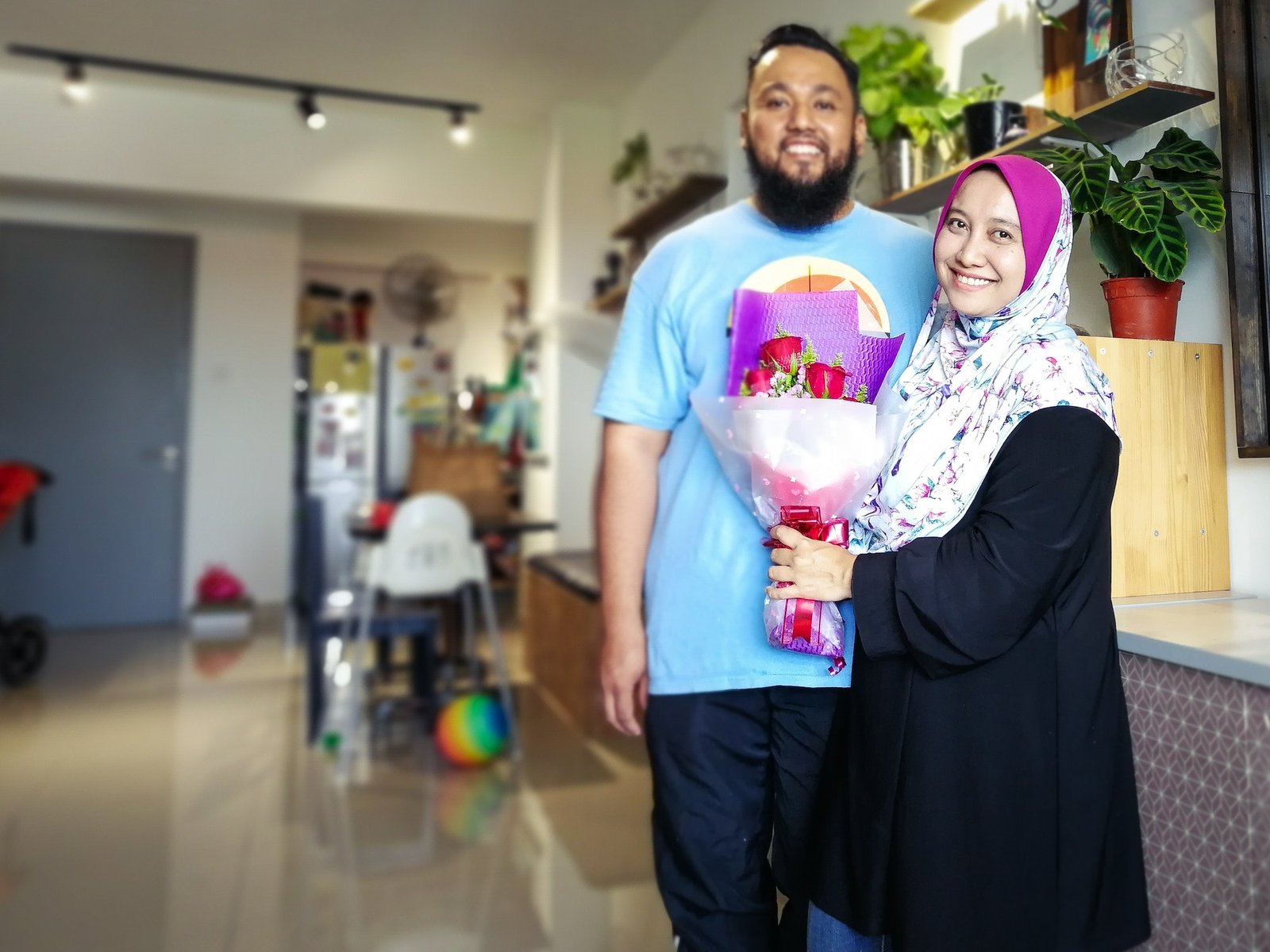 happy malaysian muslim couple celebrating anniversary at home.