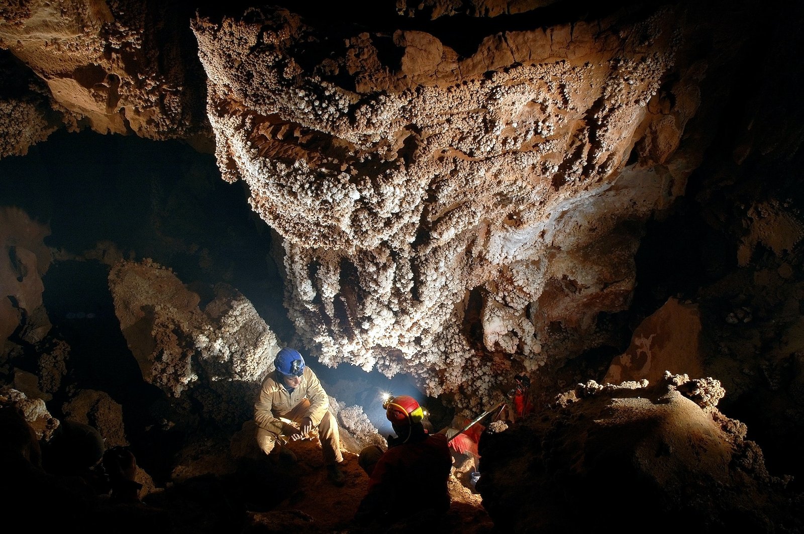 Spelunker admiring beautiful stalactites in a cave
